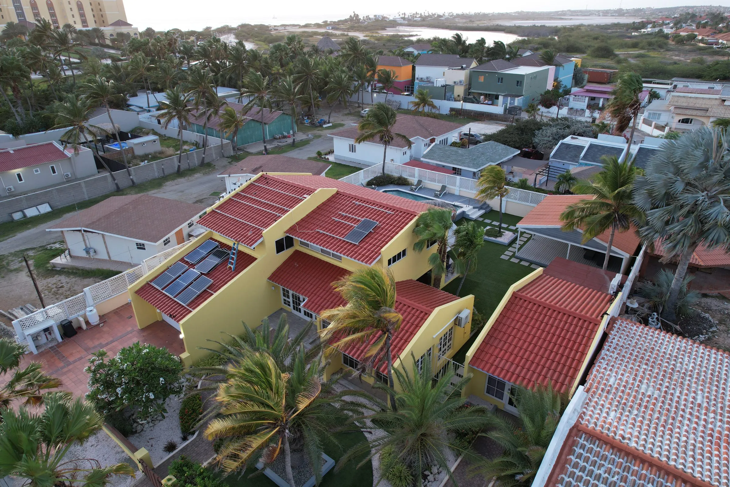 Villas with red tile roofs between palm trees